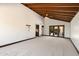 Spacious living room with wood-beamed ceilings and access to the backyard through glass doors at 4448 E Camelback Rd # 16, Phoenix, AZ 85018