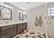 Bathroom with double sinks, modern vanity, decorative tile floor, and glass enclosed shower at 4530 E Vista Dr, Phoenix, AZ 85032