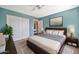 Cozy bedroom features neutral carpet, a ceiling fan, and a turquoise accent wall at 4530 E Vista Dr, Phoenix, AZ 85032