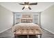 Comfortable main bedroom with ceiling fan, botanical wall art, and bench at the foot of the bed at 4530 E Vista Dr, Phoenix, AZ 85032