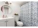 Well-lit bathroom with a vanity, toilet, and patterned shower curtain at 4615 E Southgate Ave, Phoenix, AZ 85040