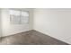 Minimalist bedroom featuring a large window with blinds, neutral paint, and carpet flooring at 4615 E Southgate Ave, Phoenix, AZ 85040