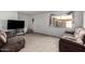 Well-lit living room with tile floors, two plush sofas, and a TV at 4615 E Southgate Ave, Phoenix, AZ 85040