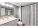 Bathroom features a modern vanity, decorative mirror, and tiled shower with stylish shower curtain at 4730 W Northern Ave # 1102, Glendale, AZ 85301