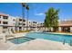 Community pool with mature palm trees, chaise lounges, and well-maintained landscaping at 4730 W Northern Ave # 1102, Glendale, AZ 85301