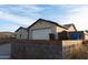 View of single-story home with stucco facade and two-car garage with a concrete driveway and blue sky background at 504 W Hartford Rd, Kearny, AZ 85137