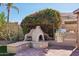 This backyard showcases a custom BBQ, brick patio, and lush, mature landscaping at 5102 E Libby St, Scottsdale, AZ 85254
