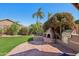 Charming backyard features a custom BBQ, green lawn, palm trees, and a blue sky at 5102 E Libby St, Scottsdale, AZ 85254