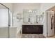 Bright bathroom with dark wood vanity, spacious mirror, and natural light at 5102 E Libby St, Scottsdale, AZ 85254