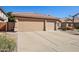 Home featuring a spacious driveway leading to a three-car garage with neutral-colored doors at 5102 E Libby St, Scottsdale, AZ 85254