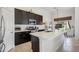 Modern kitchen with an island, stainless steel appliances, dark wood cabinets, and white countertops at 5102 E Libby St, Scottsdale, AZ 85254