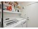 The bright laundry room has white washer and dryer, utility shelves, and white door at 5102 E Libby St, Scottsdale, AZ 85254