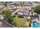 Aerial view of backyard with green grass, fence, covered patio, and pool at 5704 E Estrid Ave, Scottsdale, AZ 85254