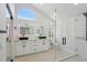 Bright and airy bathroom featuring modern dual vanities, a walk-in shower, and an arched window at 5704 E Estrid Ave, Scottsdale, AZ 85254