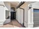 Close up of entry way with textured stucco, black rain gutters, and an arched transom window above door at 5704 E Estrid Ave, Scottsdale, AZ 85254