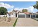 Charming single-story home with a desert landscape, barrel tile roof, and three-car garage at 5704 E Estrid Ave, Scottsdale, AZ 85254