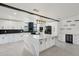 Modern kitchen with white cabinets, black appliances, and a spacious island with a marble countertop at 5704 E Estrid Ave, Scottsdale, AZ 85254