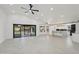 Open concept living room and kitchen with expansive tile floors and sliding glass doors to backyard at 5704 E Estrid Ave, Scottsdale, AZ 85254