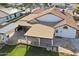 Aerial rear view showcasing a covered patio, with a large manicured lawn and a glimpse of the surrounding neighborhood at 5704 E Estrid Ave, Scottsdale, AZ 85254