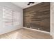Bedroom with wood accent wall, light hardwood floors, ceiling fan and window with white blinds at 730 E Tanya Trl, Phoenix, AZ 85086