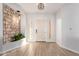 Inviting foyer with stone accent wall, plant, glass block windows, and wood flooring at 730 E Tanya Trl, Phoenix, AZ 85086