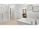 Bright bathroom featuring a modern freestanding tub, walk-in shower, and a view into the main bedroom at 7441 W Buckhorn Trl, Peoria, AZ 85383