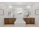 Elegant bathroom featuring double vanities, a standalone tub, and a large window offering natural light and scenic views at 7441 W Buckhorn Trl, Peoria, AZ 85383