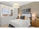 Stylish bedroom featuring a neutral color palette, modern lighting, and large window with bright natural light at 7441 W Buckhorn Trl, Peoria, AZ 85383