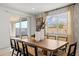 Bright dining area showcasing a large wooden table, designer chairs and slider door to the backyard at 7441 W Buckhorn Trl, Peoria, AZ 85383