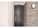 Elegant front door enhanced by stone accents and a modern exterior light fixture at 7441 W Buckhorn Trl, Peoria, AZ 85383
