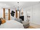 Bright main bedroom with decorative chandelier, natural light, accent furniture, and a glimpse into the ensuite bathroom at 7441 W Buckhorn Trl, Peoria, AZ 85383