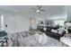 Open-concept living room with gray sofa, a ceiling fan, and views into the kitchen with barstool seating at 814 S 122Nd Ln, Avondale, AZ 85323