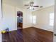 Large main bedroom features wood floors, neutral paint, ceiling fan, and an arched doorway to the ensuite bathroom at 8812 W Hess St, Tolleson, AZ 85353