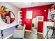 Salon interior featuring red walls, a vanity with a mirror, salon chairs, and good lighting at 8812 W Hess St, Tolleson, AZ 85353