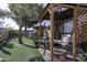 Tranquil backyard featuring a pergola-covered swing, water feature and artificial turf at 891 W Moon Shadow Dr, Casa Grande, AZ 85122
