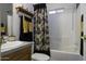 Clean bathroom featuring a shower-tub combo, decorative shower curtain, and built-in shelves at 891 W Moon Shadow Dr, Casa Grande, AZ 85122