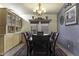 Dining room with ample seating under an elegant chandelier, enhanced by a decorative shelf and patterned rug at 891 W Moon Shadow Dr, Casa Grande, AZ 85122