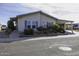 Charming home with lush landscaping, blue shutters, and a covered carport at 891 W Moon Shadow Dr, Casa Grande, AZ 85122