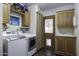 Laundry room with modern appliances, wooden cabinets and an exterior entrance at 891 W Moon Shadow Dr, Casa Grande, AZ 85122