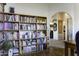 Bright living room featuring an expansive bookshelf, hard wood floors, and a glimpse into the adjoining rooms at 891 W Moon Shadow Dr, Casa Grande, AZ 85122