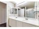 Bathroom featuring double sinks, a large mirror, towel rings and glass shelves for storage at 900 S 94Th St # 1203, Chandler, AZ 85224