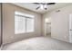 This bedroom features a ceiling fan, plush carpet and natural light from a large window at 900 S 94Th St # 1203, Chandler, AZ 85224