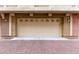 Attached garage showcasing a tan-colored door with decorative windows and brick-paved driveway at 900 S 94Th St # 1203, Chandler, AZ 85224