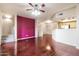 Open-concept living room featuring hardwood floors, a purple accent wall, and a staircase at 900 S 94Th St # 1203, Chandler, AZ 85224