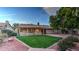 Well-maintained backyard with lush green grass, mature trees, covered patio, and desert landscaping at 9445 S La Rosa Dr, Tempe, AZ 85284