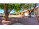 Expansive backyard featuring gravel, mature shade trees, and a covered patio perfect for outdoor entertaining at 9445 S La Rosa Dr, Tempe, AZ 85284