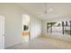 Bright primary bedroom featuring a ceiling fan, large window and arched doorway to the primary bath at 9445 S La Rosa Dr, Tempe, AZ 85284