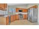 Bright kitchen showcasing stainless steel appliances, wooden cabinets, a stainless steel refrigerator, and tile flooring at 9445 S La Rosa Dr, Tempe, AZ 85284