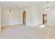 Spacious living room with plush carpeting, arched doorways, and a modern ceiling fan fixture at 9445 S La Rosa Dr, Tempe, AZ 85284