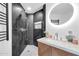 Modern bathroom features an oval mirror with overhead lighting, as well as a shower with black marble tile at 1040 E Osborn Rd # 1004, Phoenix, AZ 85014